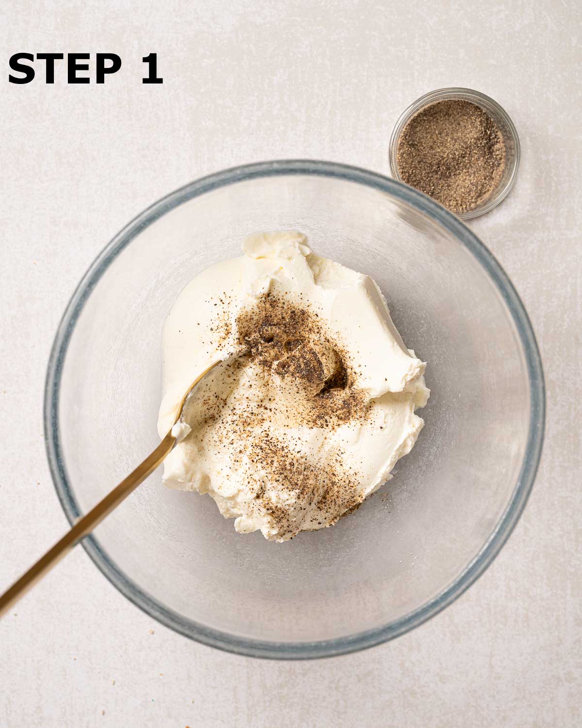 Cream cheese and ground black pepper in a mixing bowl.