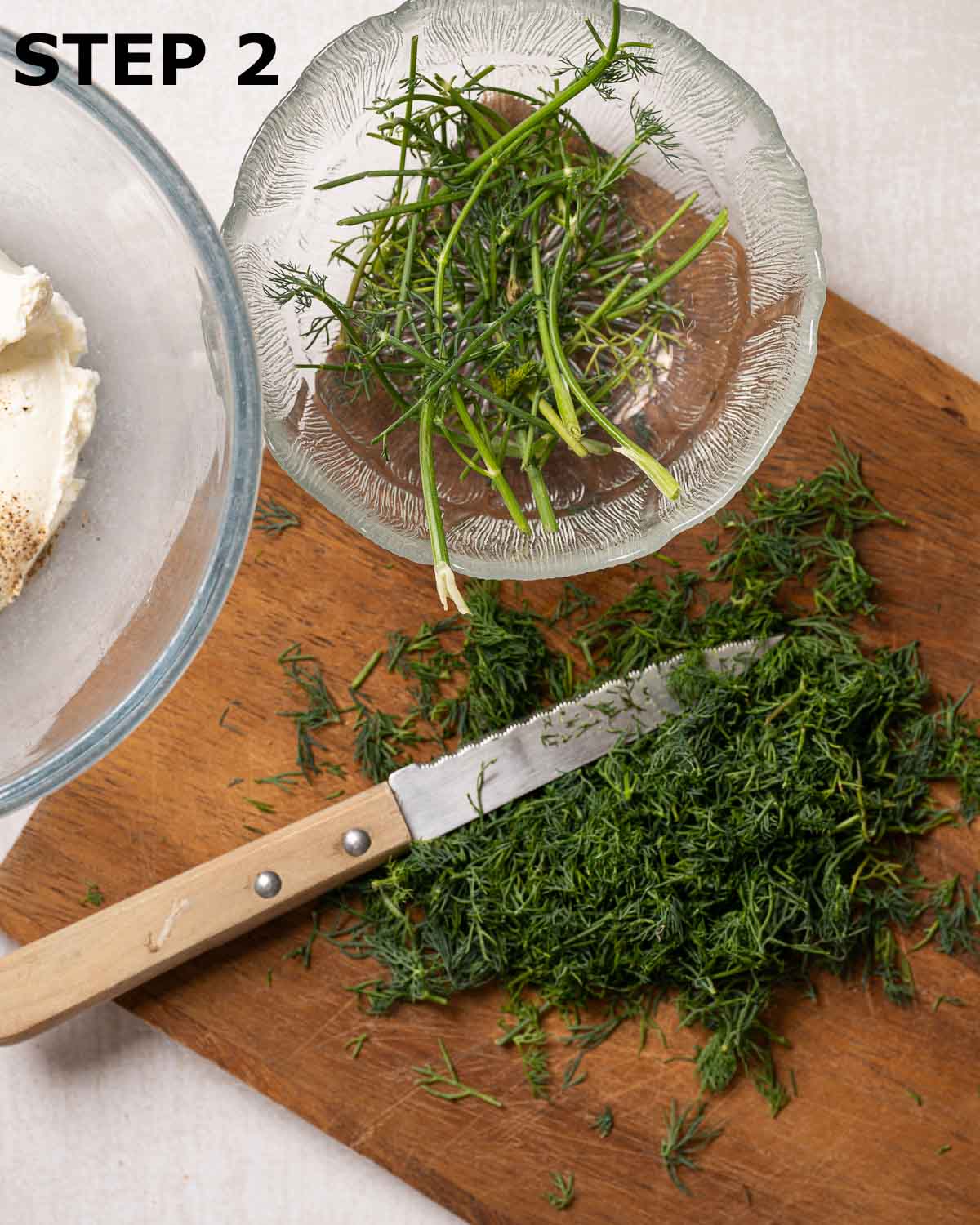 Fresh dill chopped on a wooden board.