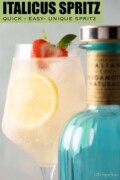 Labelled Italicus spritz cocktail with lemon and strawberry garnish behind a bottle of Italicus liqueur.