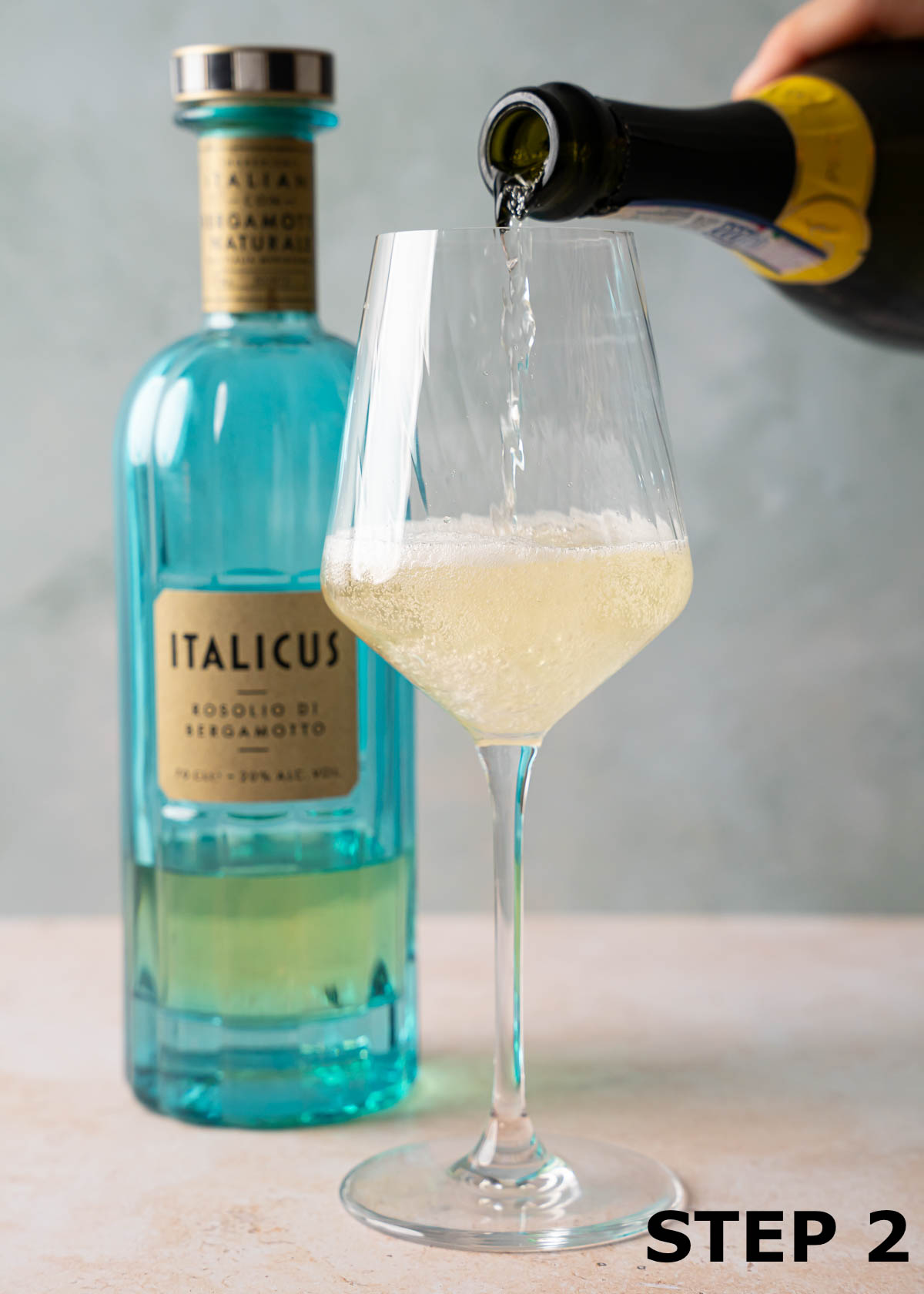 A person pouring Prosecco into a wine glass for a spritz cocktail.