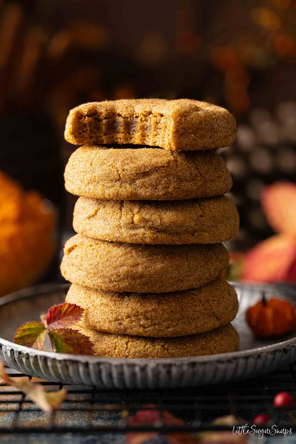 A stack of soft pumpkin pie spice cookies and the top one has a bite taken out.