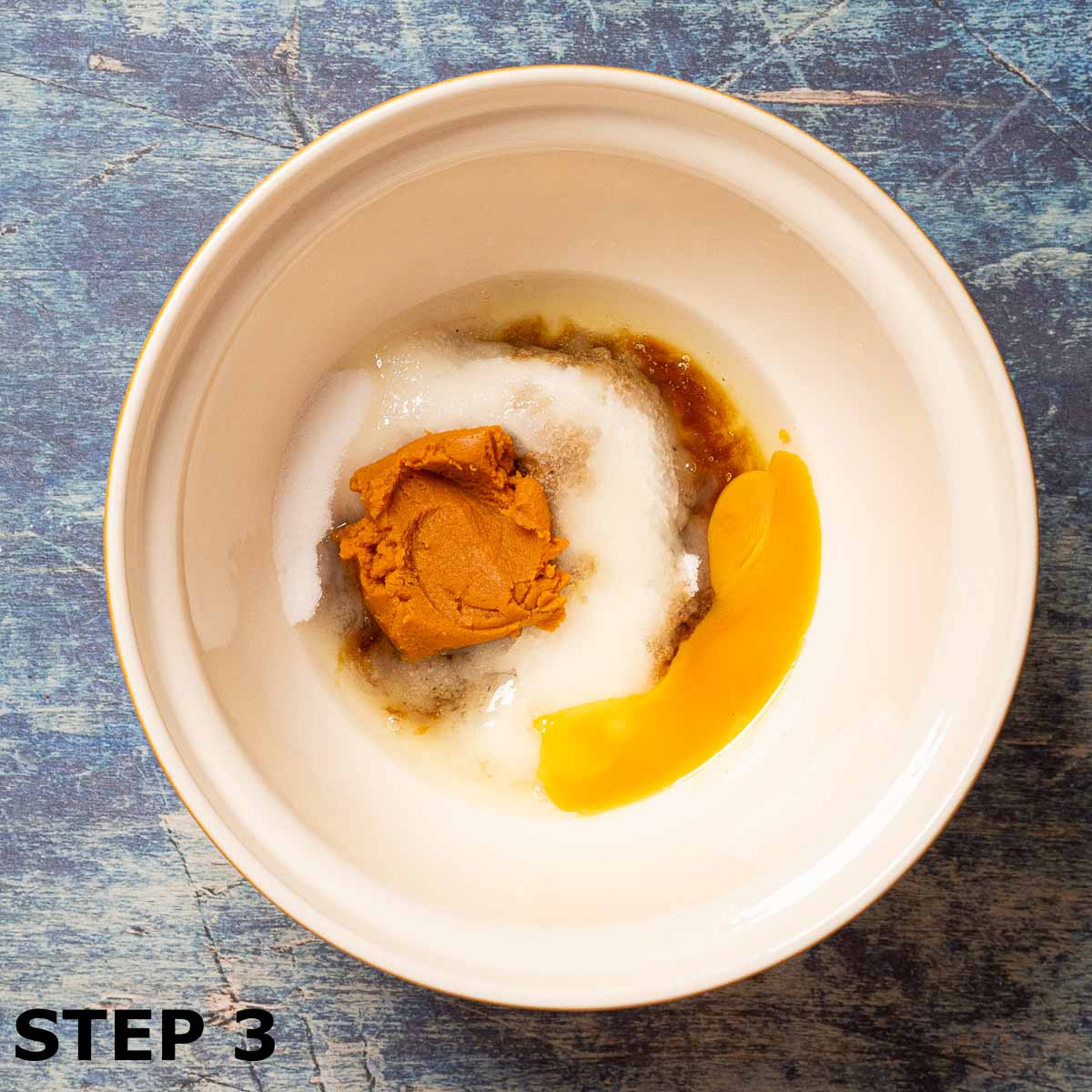 Sugar, pumpkin puree and egg in a mixing bowl.